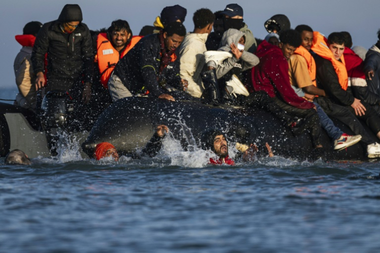 Des migrants tentent d'embarquer sur un bateau de passeurs afin de traverser la Manche au large de Gravelines (nord de la France) le 27 septembre 2025 ( AFP / Sameer Al-DOUMY )