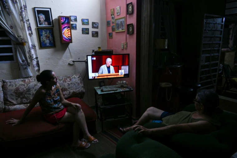 Des Cubains regardent un discours télévisé du président Miguel Diaz-Canel lors de la troisième session extraordinaire de l'Assemblée nationale du pouvoir populaire de Cuba, le 18 juin 2026 à La Havane ( AFP / YAMIL LAGE )