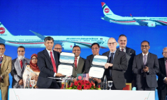 Photo diffusée par Biman Bangladesh Airlines montrant le PDG de compagnie aérienne, Kaizer Sohel Ahmed (g), et le vice-président de Boeing, Paul Righi (d), échangeant des documents après la signature d'un accord à Dacca, le 30 avril 2026 au Bangladesh ( Biman Bangladesh Airlines  / Handout )