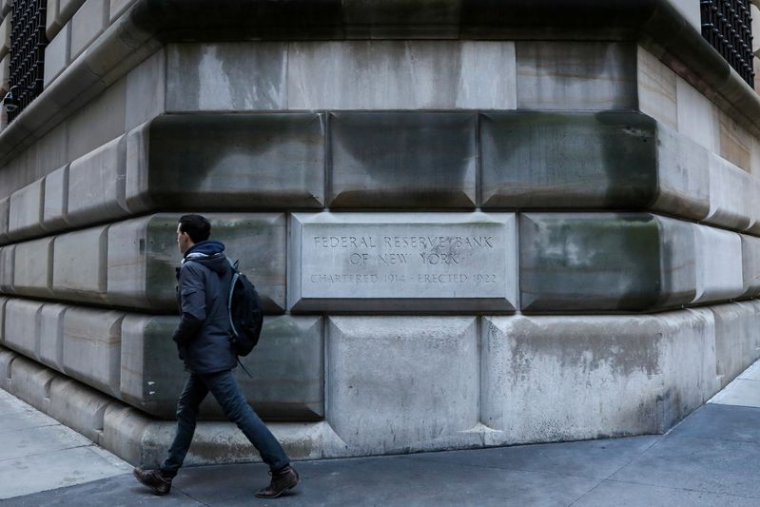 Un homme passe devant la pierre angulaire de la Banque fédérale de réserve de New York