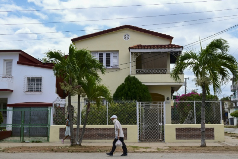 Un passant marche devant une maison dans un quartier cossu de La Havane, le 23 avril 2026 ( AFP / YAMIL LAGE )