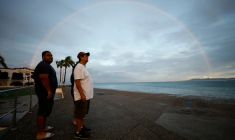 Des personnes se tiennent le long d’une promenade sous un arc-en-ciel à Puerto Vallarta, au Mexique, le 12 octobre 2026 ( AFP / ULISES RUIZ )