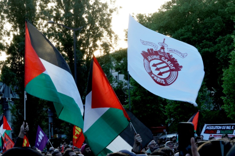 Des drapeaux palestiniens et un drapeau du groupe antifasciste "Jeune Garde" lors d'une manifestation contre la décision du ministre de l'Intérieur de dissoudre "Jeune Garde" et le collectif "Urgence Palestine", place Stalingrad à Paris, le 6 mai 2025 ( AFP / GEOFFROY VAN DER HASSELT )