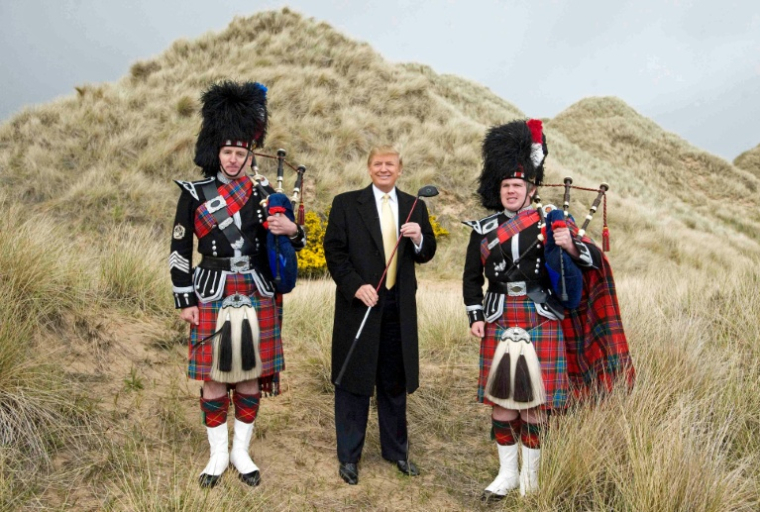 Donald Trump entre deux joueurs de cornemuse, le 27 mai 2010, lors d'une visite sur le site de construction de son golf près d'Aberdeen, en Ecosse ( AFP / DEREK BLAIR )