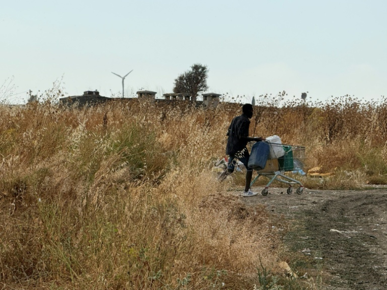 Residents use a shopping trolley to get water from tankers, but it is not suitable for drinking. ( AFP / Tiziana FABI )