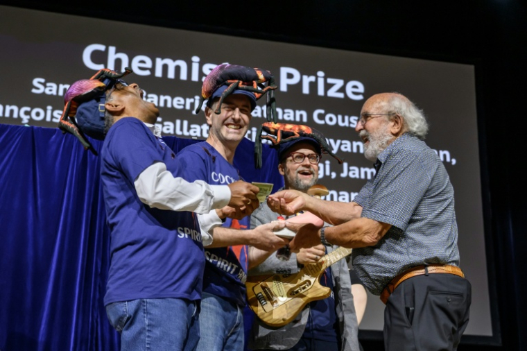 Le professeur indien Subramanian Ramaswamy (gauche), Leonard Chavas (centre) et le docteur Nathan Coussens (2e à droite) reçoivent leur prix des mains de Michel Mayor (tout à droite), lauréat du prix Nobel de physique 2019, lors de la cérémonie des prix Ig Nobel 2026 à Zurich, le 3 septembre 2026 ( AFP / Fabrice COFFRINI )