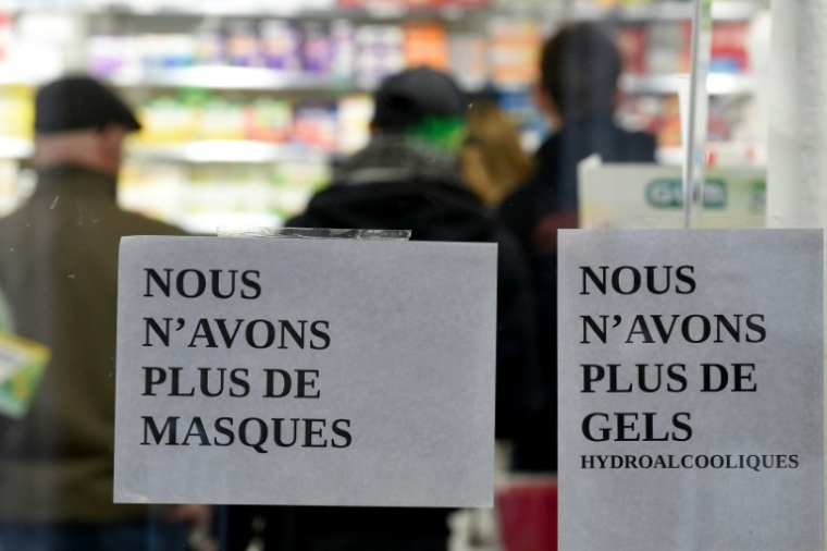 Des affichettes "plus de masques", "plus de gels" à l'entrée d'une pharmacie à Paris, le 16 mars 2020 ( AFP / ERIC PIERMONT )