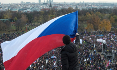Un homme brandit un drapeau tchèque au-dessus d'une foule de manifestants lors d'un rassemblement contre le Premier ministre tchèque Andrej Babis, à la veille de l'anniversaire de la Révolution de velours, à Prague, le 16 novembre 2019 ( AFP / Michal Cizek )