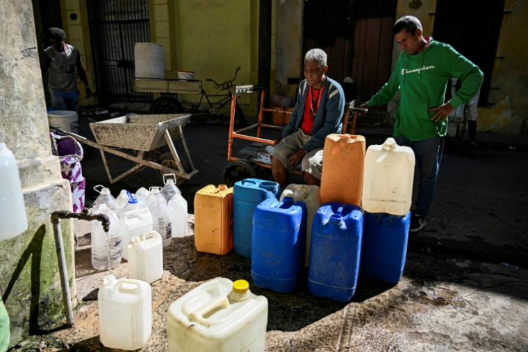 Des habitants de La Havane font la queue pour remplir leurs bidons d'eau pendant une panne d'électricité nationale à Cuba, le 22 mars 2026 ( AFP / YAMIL LAGE )