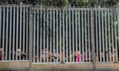 Des migrants se tiennent près du mur à la frontière entre la Pologne et la Biélorussie, près de Białowieża