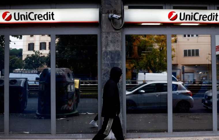 Une personne passe devant une agence bancaire UniCredit