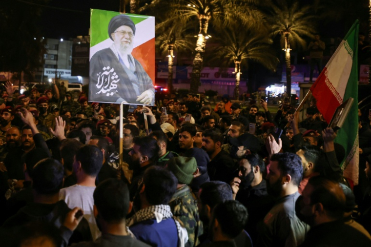 Un portrait du guide suprême iranien Ali Khamenei, tué au premier jour de la guerre, est brandi au cours des funérailles de membres d'une milice irakienne pro-Téhéran à Bagdad, le 17 mars 2026 ( AFP / AHMAD AL-RUBAYE )