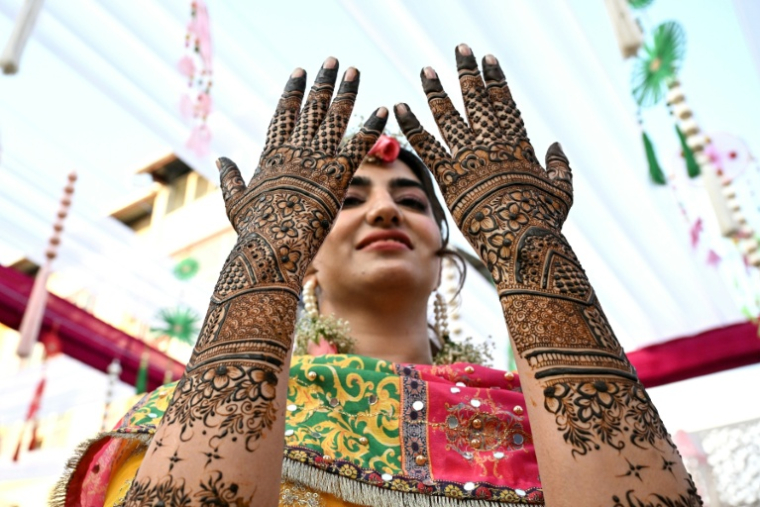 Une mariée regarde ses mains décorées avec du henné, à Srinagar, principale ville du Cachemire administré par l’Inde, le 1er juin 2026 ( AFP / Tauseef MUSTAFA )