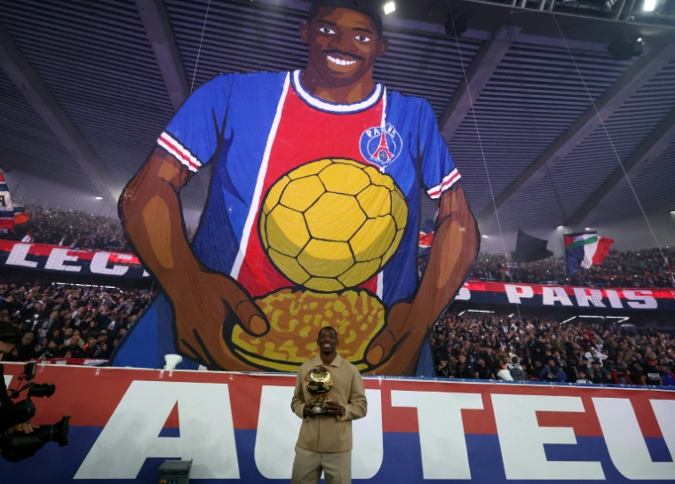 L'attaquant n°10 du Paris Saint-Germain Ousmane Dembélé et son trophée du Ballon d'Or lors d'une cérémonie après le match de football de L1 entre le Paris Saint-Germain (PSG) et Auxerre au stade du Parc des Princes à Paris, le 27 septembre 2025 ( AFP / FRANCK FIFE )