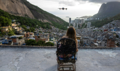 Une touriste se fait filmer par un drone sur le toit d'une maison dans la favela de Rocinha, à Rio de Janeiro, au Brésil, le 5 mars 2026 ( AFP / Pablo PORCIUNCULA )