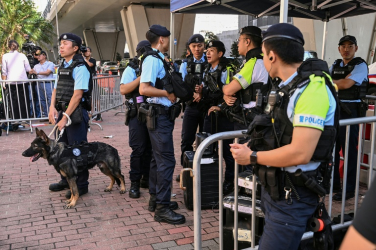 Des agents de police devant le tribunal en amont du prononcé des peines pour des militants de la mémoire de Tiananmen, à Hong Kong, le 11 septembre 2026 ( AFP / Peter PARKS )