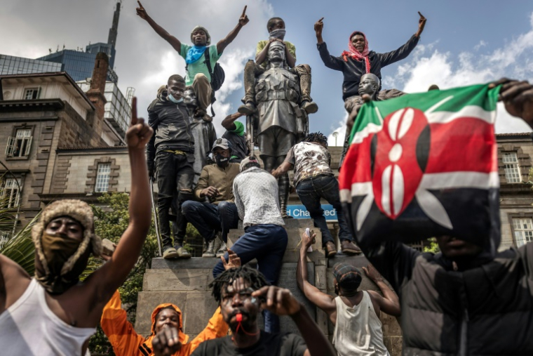 Des manifestants escaladent une statue commémorant les soldats d'Afrique de l'Est qui ont combattu pendant la Première Guerre mondiale alors qu'ils scandent des slogans anti-gouvernementaux à Nairobi, le 25 juin 2025 au Kenya ( AFP / Luis TATO )