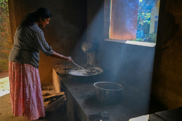 Padma Nandani Thibbotuwa, l'épouse de Sarath Ananda, récolteur de sève de kithul, prépare du sucre de palme, dans le village d'Ambegoda,le 26 janvier 2026 au Sri Lanka ( AFP / Ishara S. KODIKARA )