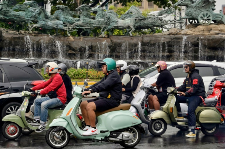 Des conducteurs de Vespa dans une rue de Jakarta le 28 janvier 2025 ( AFP / BAY ISMOYO )