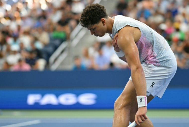 Ben Shelton souffrant de l'épaule gauche contraint à l'abandon face à Adrian Mannarino à l'US Open, le 29 août 2025 ( AFP / ANGELA WEISS )