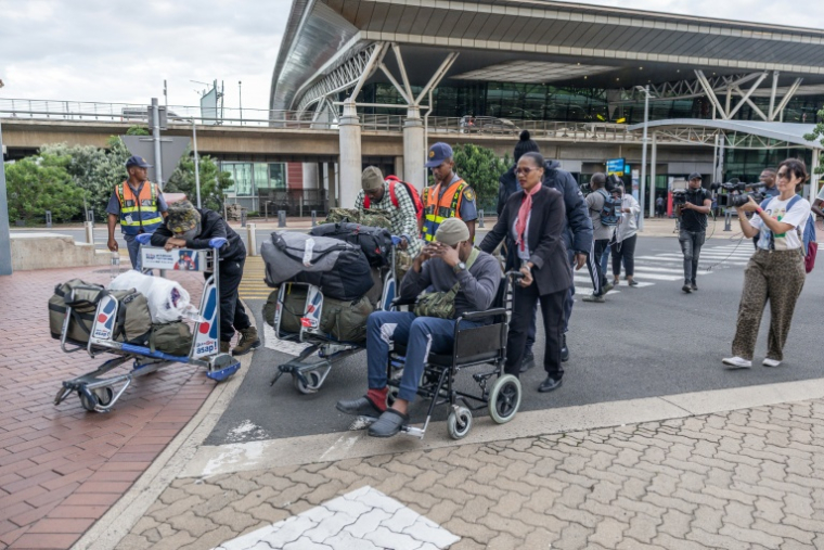 Un groupe de 11 Sud-Africains, qui auraient été attirés pour aller combattre aux côtés de soldats russes dans la guerre contre l’Ukraine, arrive à l’aéroport international King Shaka de Durban le 25 février 2026 ( AFP / RAJESH JANTILAL )