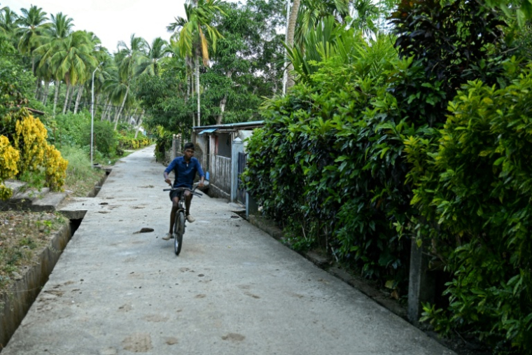 Un garçon à vélo dans le village de Campbell Bay, sur l'île de Grande Nicobar, dans l'archipel indien des Andaman-et-Nicobar, le 26 mars 2026  ( AFP / R. Satish BABU )