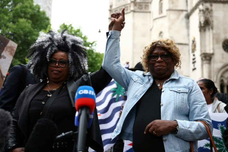 Les Chagossiennes Bertrice Pompe (à gauche) et Bernadette Dugasse (à droite) à la sortie de la Haute Cour de Londres le 22 mai 2025 après avoir été débouté du recours contre l'accord de restitution des îles Chagos à Maurice ( AFP / HENRY NICHOLLS )