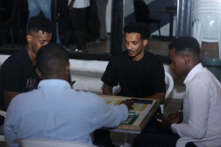 Mahad Maxamud joue à un jeu de société lors d'une sortie entre amis à Mogadishu le 6 décembre 2025 ( AFP / Hassan Ali ELMI )