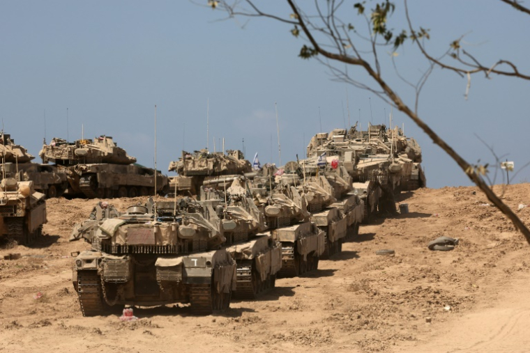Une photo prise depuis le sud d'Israël montre des véhicules militaires israéliens déployés près de la barrière frontalière avec le territoire palestinien assiégé, le 17 septembre 2025  ( AFP / Jack GUEZ )