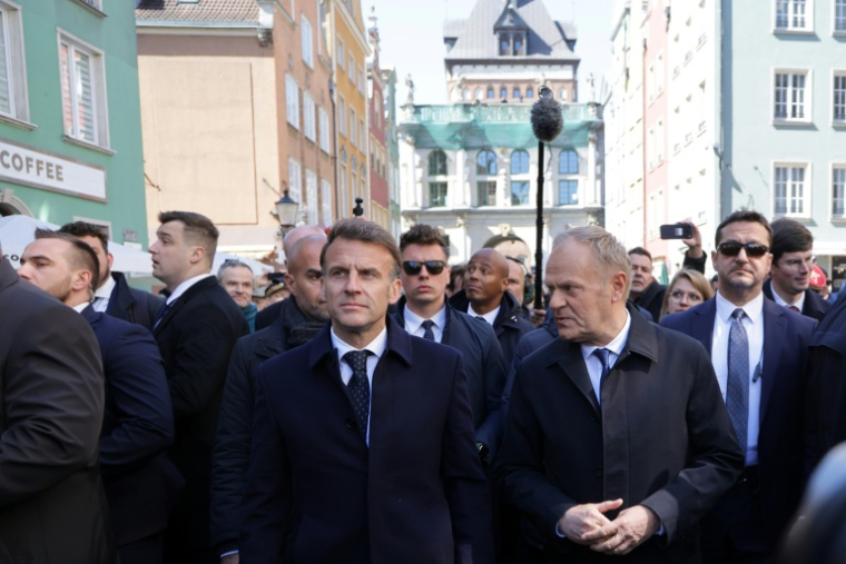 FLe président français Emmanuel Macron (g) accueilli par le Premier ministre polonais Donald Tusk (d) à la Porte Dorée (Zlota Brama), dans le centre-ville de Gdansk, lors d'une visite en Pologne, le 20 avril 2026 ( AFP / Ludovic MARIN )