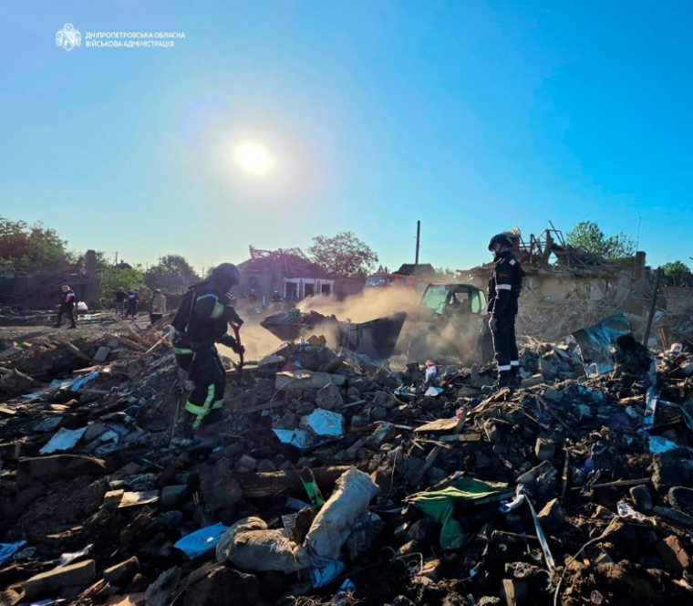 Des secouristes ukrainiens fouillent les décombres d'une maison détruite dans une frappe russe dans le village de Radouchné qui a laissé dix membres d'une même famille présumés morts, sur cette photo fournie par l'administration militaire de la région de Dnipropetrovsk le 30 juillet 2026 ( Dnipropetrovsk Regional Military Administration / Handout )