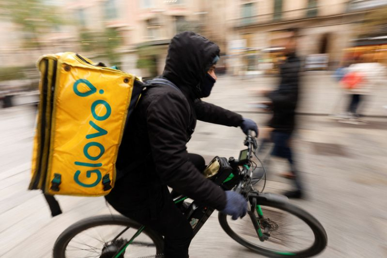 Un livreur de Glovo passe dans une zone piétonne à Barcelone