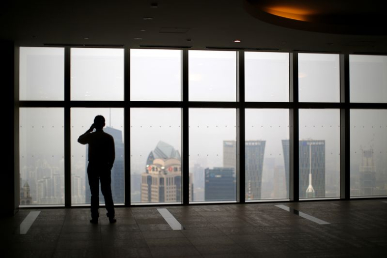 Un homme regarde la ville de Shanghai, en Chine