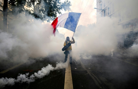Un manifestant agite un drapeau français au milieu des gaz lacrymogènes lors d'une nouvelle manifestation contre la vie chère, le 31 octobre 2026 à Lyon ( AFP / JEFF PACHOUD )