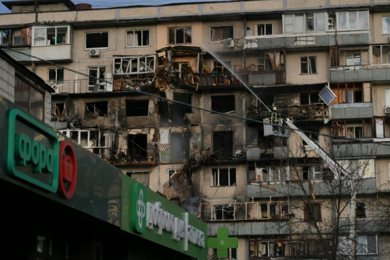 Un pompier asperge un immeuble endommagé par une explosion après une attaque russe sur la capitale ukrainienne, le 14 novembre 2025 à Kiev ( AFP / OLEKSII FILIPPOV )