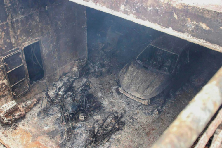 Photo prise le 11 septembre 2026 et diffusée par les garde-côtes philippins (PCG), montrant un véhicule calciné et des carcasses brûlées de motos dans la cale du navire M/V June Aster, au large de la ville de Coron, dans la province de Palawan, aux Philippines ( Garde-côtes philippins (PCG) / Handout )