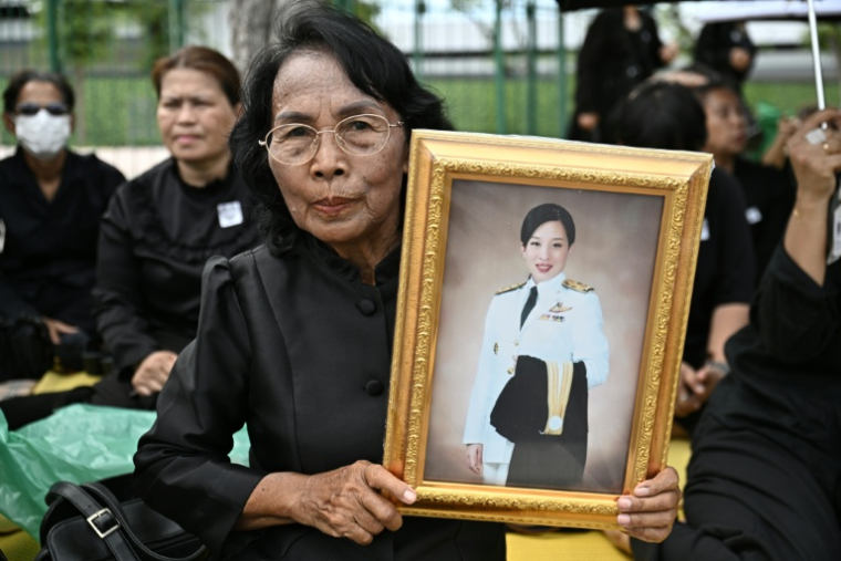 Une femme en deuil tient un portrait de la princesse défunte Bajrakitiyabha Mahidol devant le Grand Palais, le 13 juin 2026 à Bangkok, en Thaïlande ( AFP / Lillian SUWANRUMPHA )