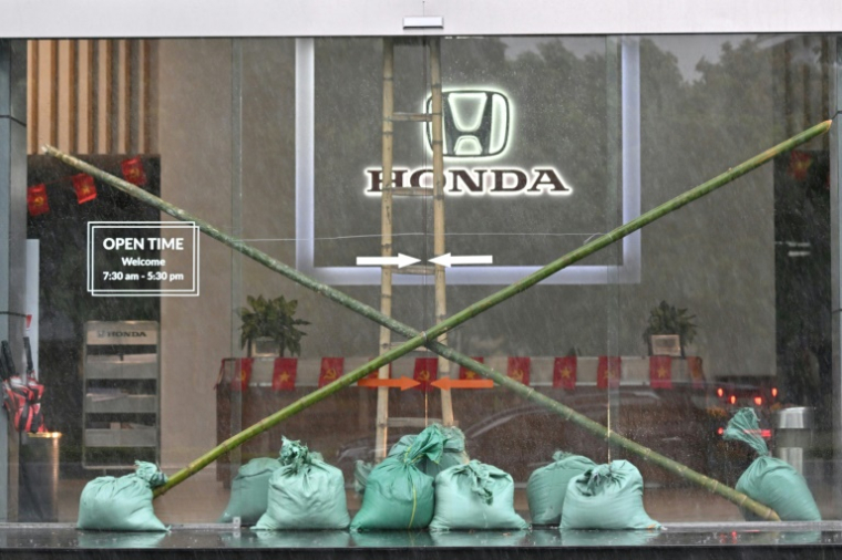 L'entrée d'un concessionnaire automobile renforcée par des sacs de sable et des piquets de bambou à Vinh, ville côtière de la province de Nghe An, avant l'arrivée du typhon Kajiki, le 25 août 2025 au Vietnam ( AFP / Nhac NGUYEN )