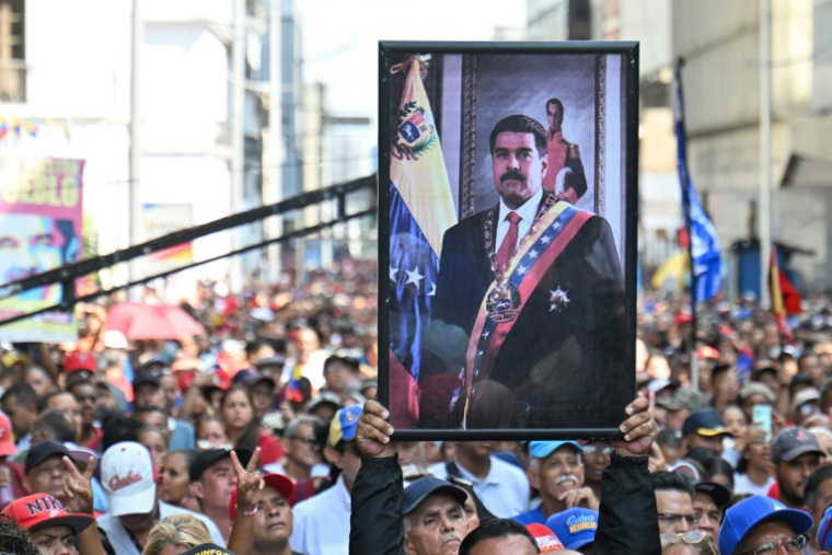 Un partisan du président vénézuélien déchu Nicolas Maduro porte son portrait lors d'un rassemblement devant l'Assemblée nationale à Caracas, le 5 janvier 2026 ( AFP / Juan BARRETO )
