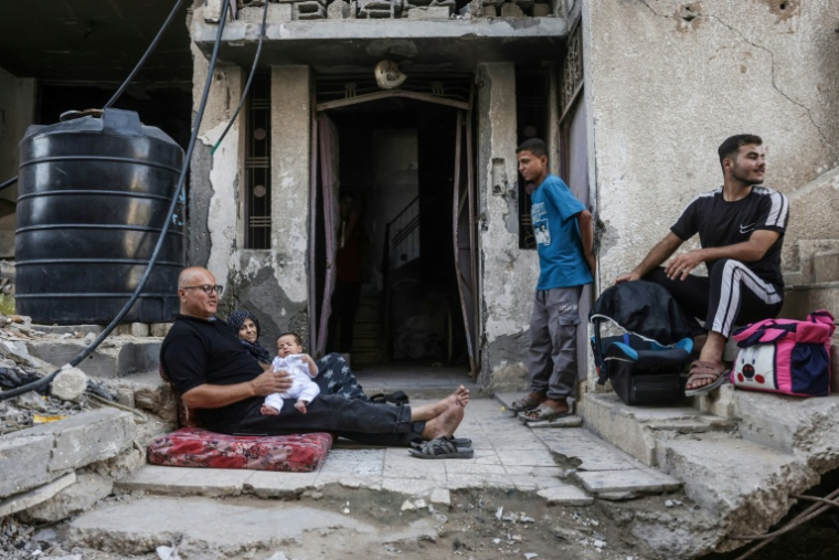Des Palestiniens devant un bâtiment endommagé par des frappes israéliennes à Khan Younès, dans le centre de la bande de Gaza, le 31 juillet 2026 ( AFP / Bashar Taleb )