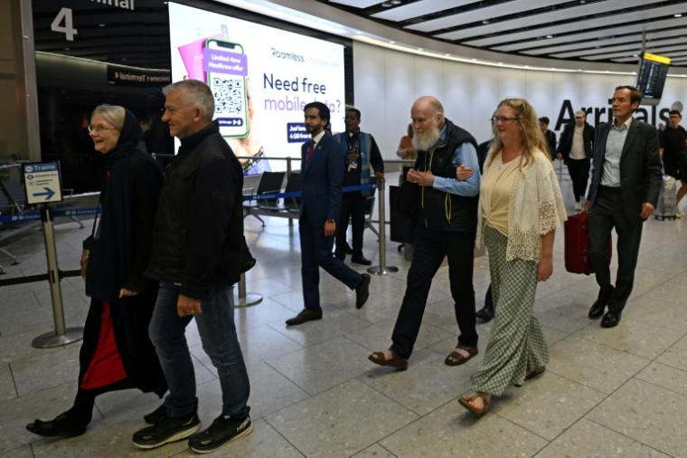Peter Reynolds (C) et Barbie Reynolds (L) , samedi 20 septembre 2025 à leur arrivée à l'aéroport d'heathrow à Londres. ( AFP / JUSTIN TALLIS )