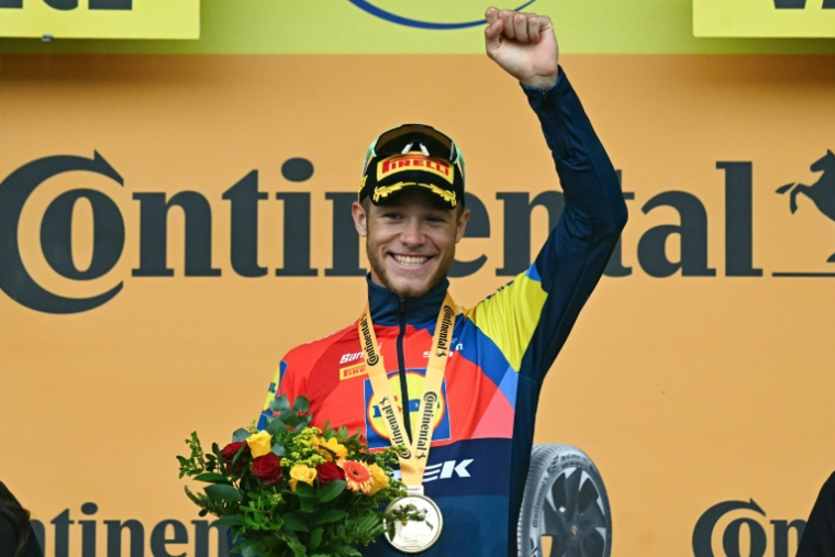 Jonathan Milan célèbre sur le podium sa victoire lors de la 17e étape du Tour de France, à Valence, le 23 juillet 2025 ( AFP / Loic VENANCE )
