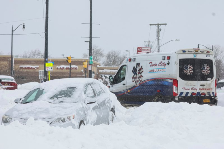 Une ambulance passe devant une voiture abandonnée pendant une tempête hivernale qui a frappé la région de Buffalo