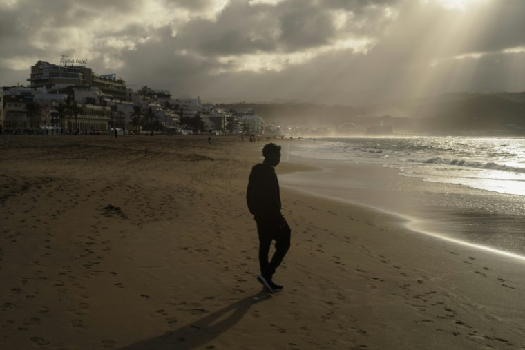 Le migrant sénégalais Ousmane Ly sur la plage de Las Canteras, le 19 janvier 2026, peu après son arrivée aux Canaries après plusieurs jours en mer dans une embarcation partie des côtes gambiennes ( AFP / MICHELE CATTANI )