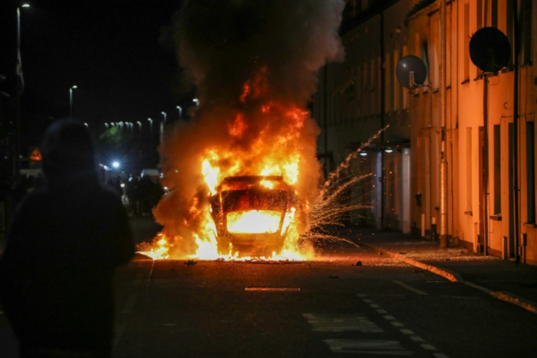 Véhicule incendié lors d’une manifestation anti-immigration à Ballymena (Irlande du Nord), le 10 juin 2025 ( AFP / PAUL FAITH )