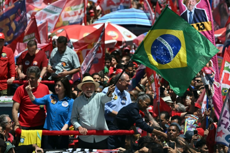 Le président brésilien de gauche Luiz Inacio Lula da Silva (C) agite le drapeau national lors d'un meeting de campagne à la veille du premier tour de la présidentielle, le 3 octobre 2026 à Sao Paulo ( AFP / Luis ROBAYO )