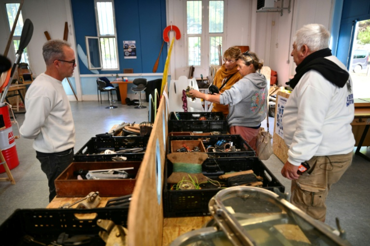 Thomas Bekkers (G) et Oscar Damaso (D) discutent avec des clients dans la ressourcerie de la Tribu maritime, le 7 novembre 2025 à Port-Saint-Louis-du-Rhône, dans les Bouches-du-Rhône ( AFP / Christophe SIMON )