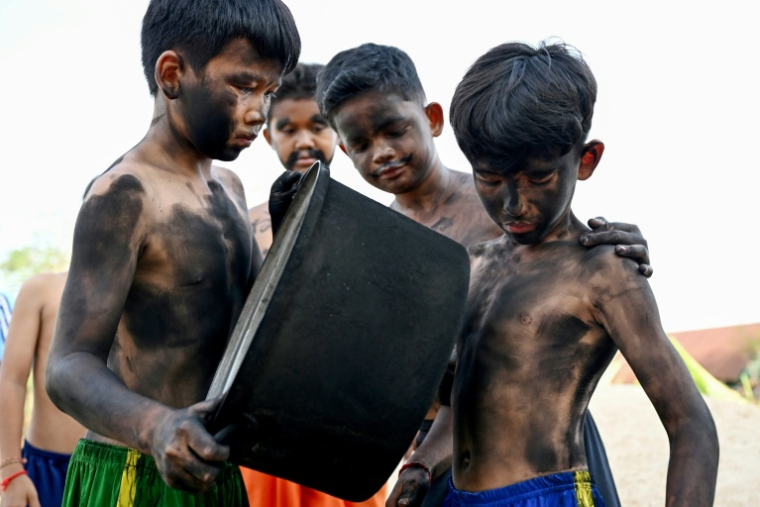 Des enfants se teignent le corps en noir pour célébrer le festival Pring Ka-Ek, le 21 mai 2026 au Cambodge ( AFP / TANG CHHIN Sothy )
