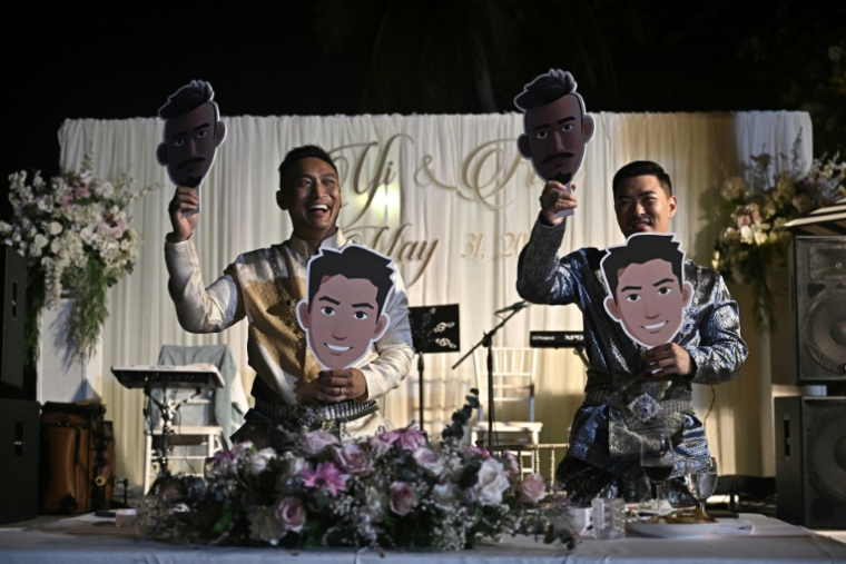 Les Chinois Song Jihan (d) et Wang Zengyi lors de leur mariage près de Pattaya, en Thaïlande, le 31 mai 2025 ( AFP / Lillian SUWANRUMPHA )