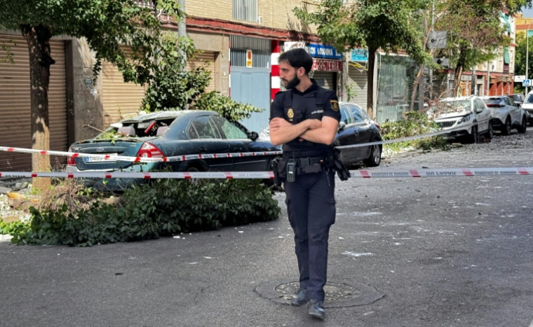Un policier dans une rue fermée à la circculation, près de véhicules endommagés par un séisme de 4,8 à Grenade, le 18 août 2026 en Espagne ( AFP / STRINGER )